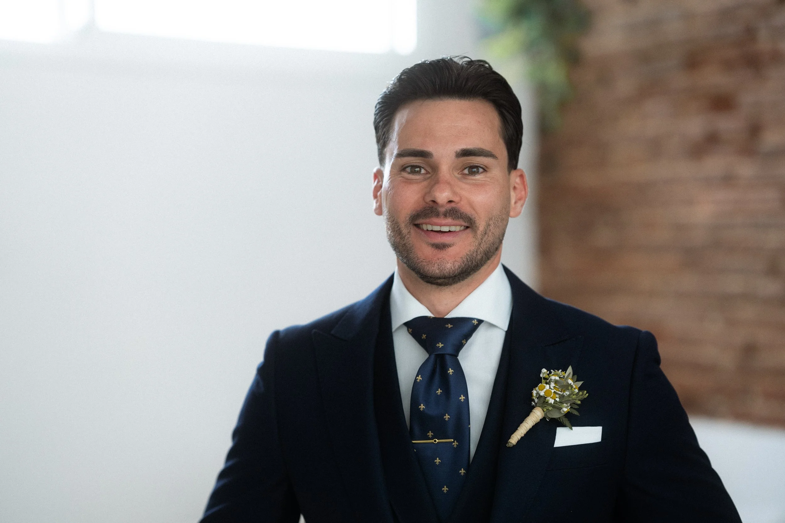 Hombre con traje oscuro y corbata azul en interiores