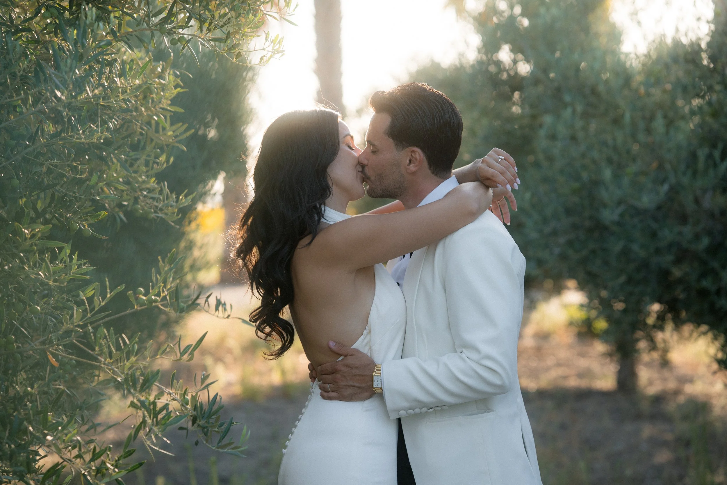 Una pareja leyéndose en un cenario natural  mientras se besan y abrazan.