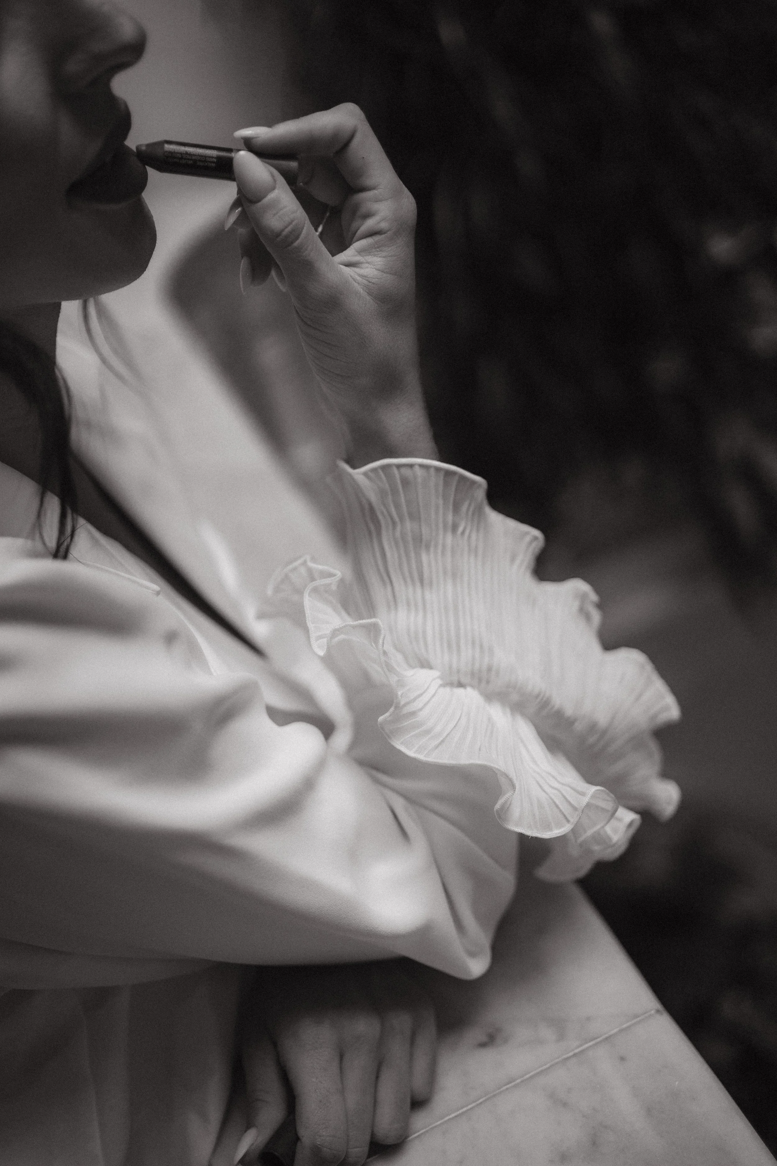 Primer plano en blanco y negro de una mujer aplicándose labial