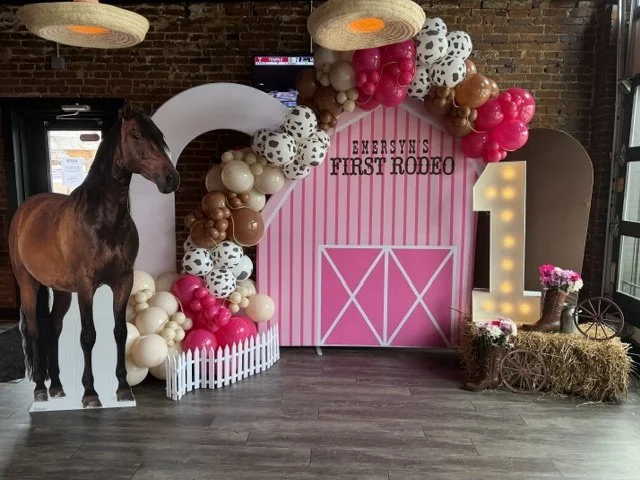 Pink barn backdrop, horse prop, and marquee number 1 for a "First Rodeo" birthday party in Philadelphia.