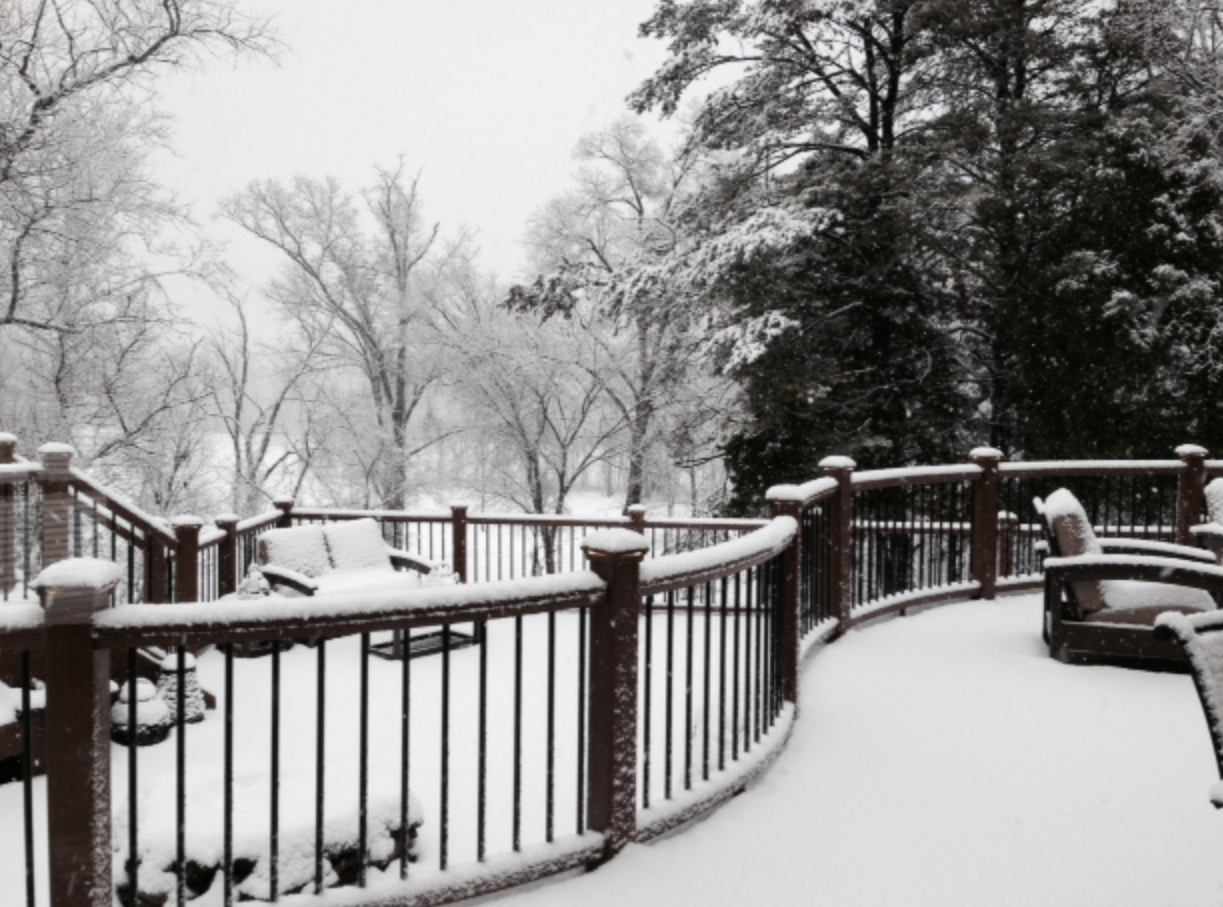 Snow covered deck with railing and patio furniture