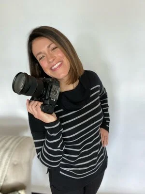 A professional headshot of a smiling woman who works as a brand photographer.
