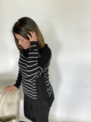 A full-body selfie of a woman smiling, demonstrating a good angle for taking a selfie with an iPhone 11 Plus.