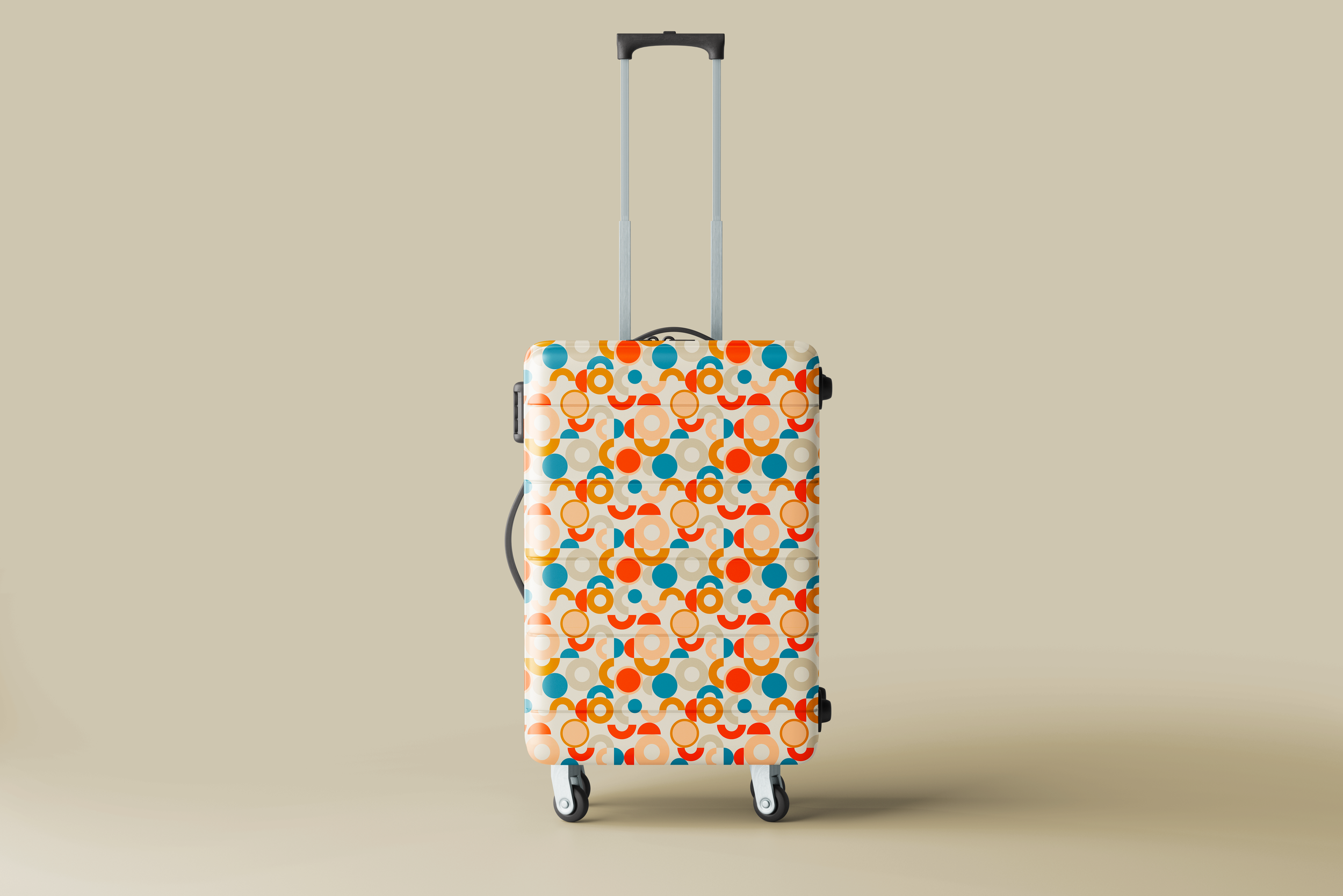 A rolling suitcase with a colorful, geometric pattern featuring circles and semi-circles in orange, blue, beige, and white, set against a neutral background.