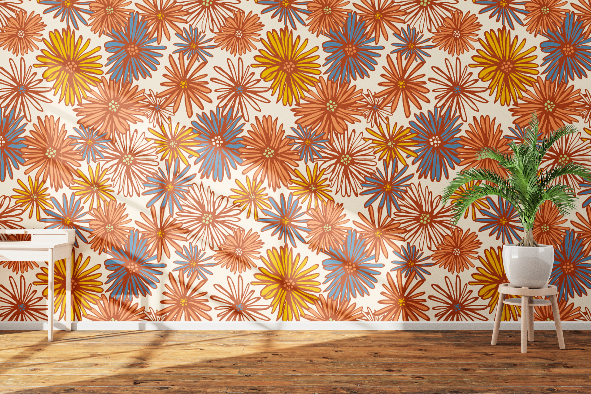 A wall covered with colorful floral wallpaper featuring orange, blue, and yellow flowers. There is a small white table on the left side and a white stool with a large potted green plant on the right side. The floor is wooden with a natural finish.