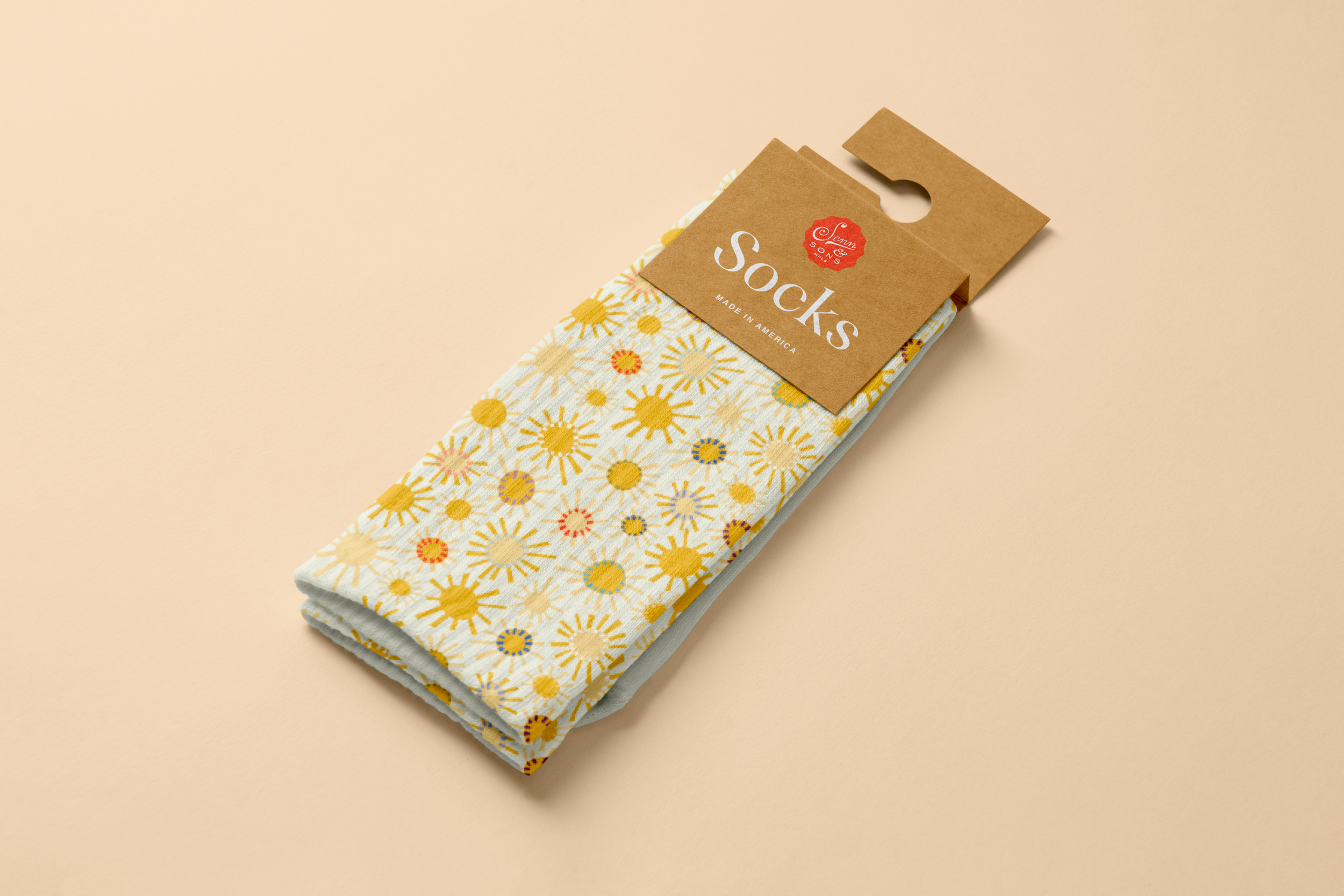 A pair of socks with a colorful floral pattern featuring yellow, orange, purple, and blue flowers, folded and attached to a cardboard holder labeled "socks" with a red logo, against a light beige background.