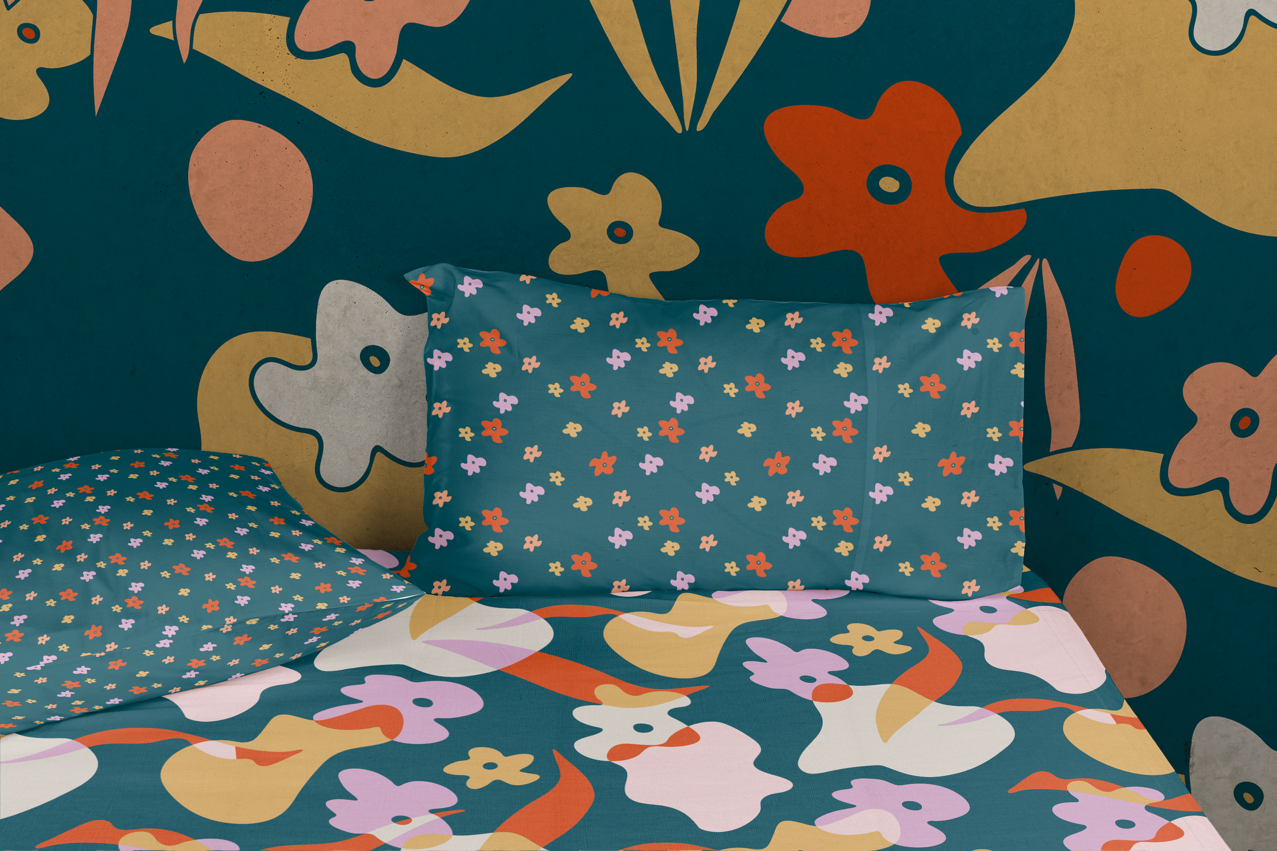 A bedroom with a bed and pillows that have a colorful flower pattern, set against a wall with an abstract floral mural in shades of yellow, orange, pink, and green.