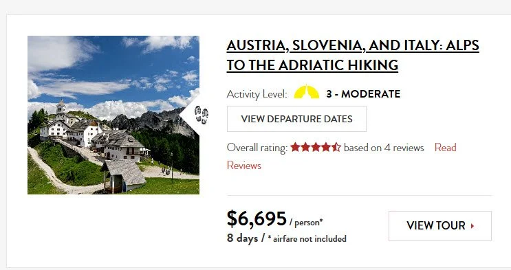 Scenic view of a mountain village with alpine-style houses, green lawns, and rocky peaks in the background, under a partly cloudy sky.