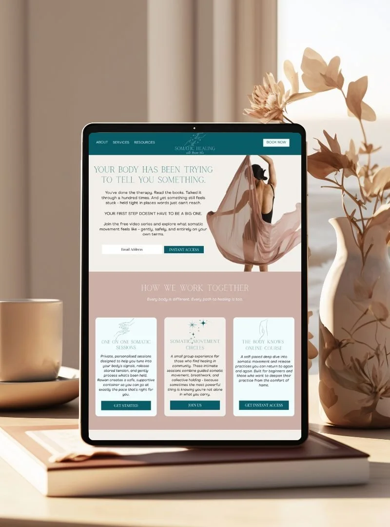 an iPad on a table next to a vase of flowers showing a website for a trauma-informed somatic practitioner