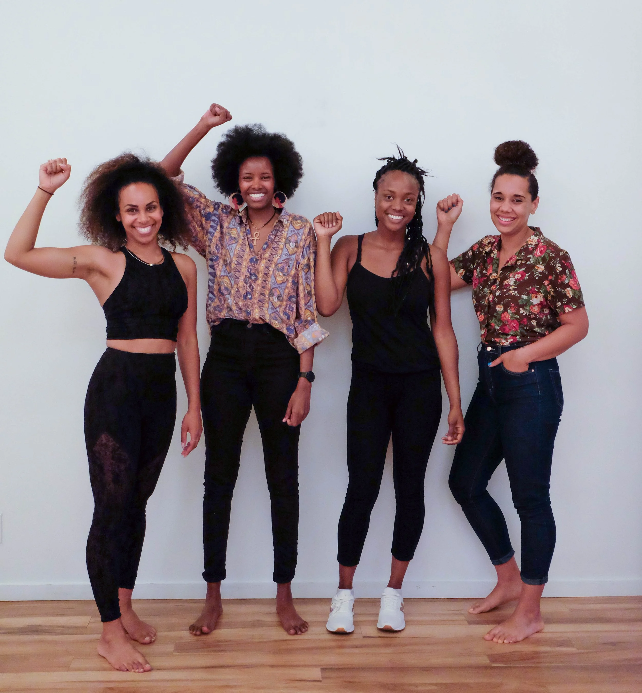Photo of Rachel with three other Black femmes, all raising their fists in the Black panther power sign