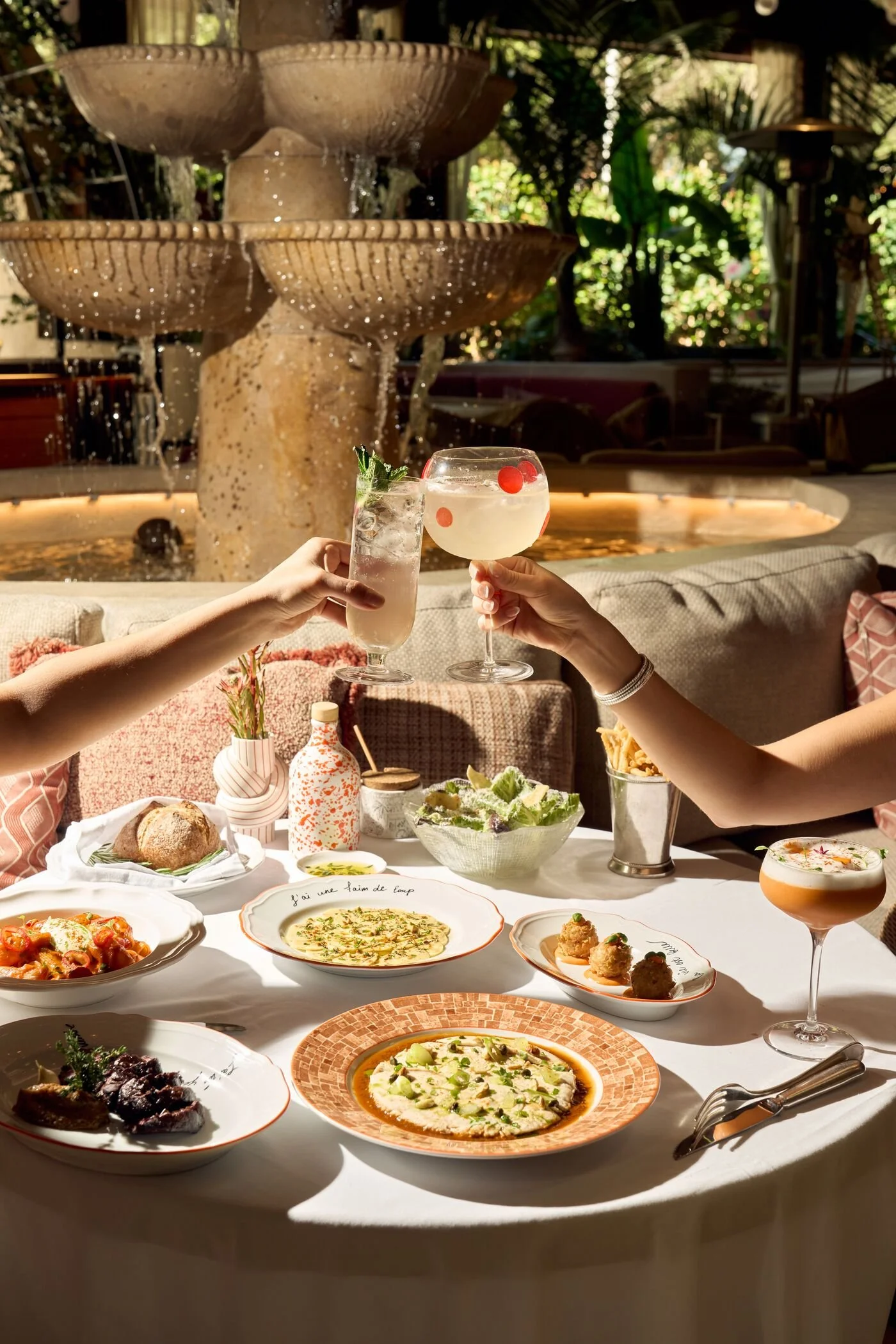 Two girls dining in the outdoor section of CLAUDIE Restaurant, eating the French and Italian cuisine.