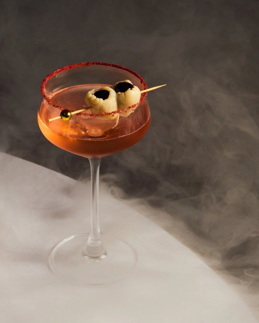 A cocktail for a night wrapped in allure and mystery. Atian Rose Gin, rectified lychee, raspberry, and sparkling wine set the mood at CLAUDIE this Halloween. Reserve your table now 🥀 🕯️