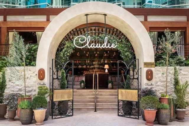 The entrance of Claudie, with a white stone arch leading to the inside of the restaurant.