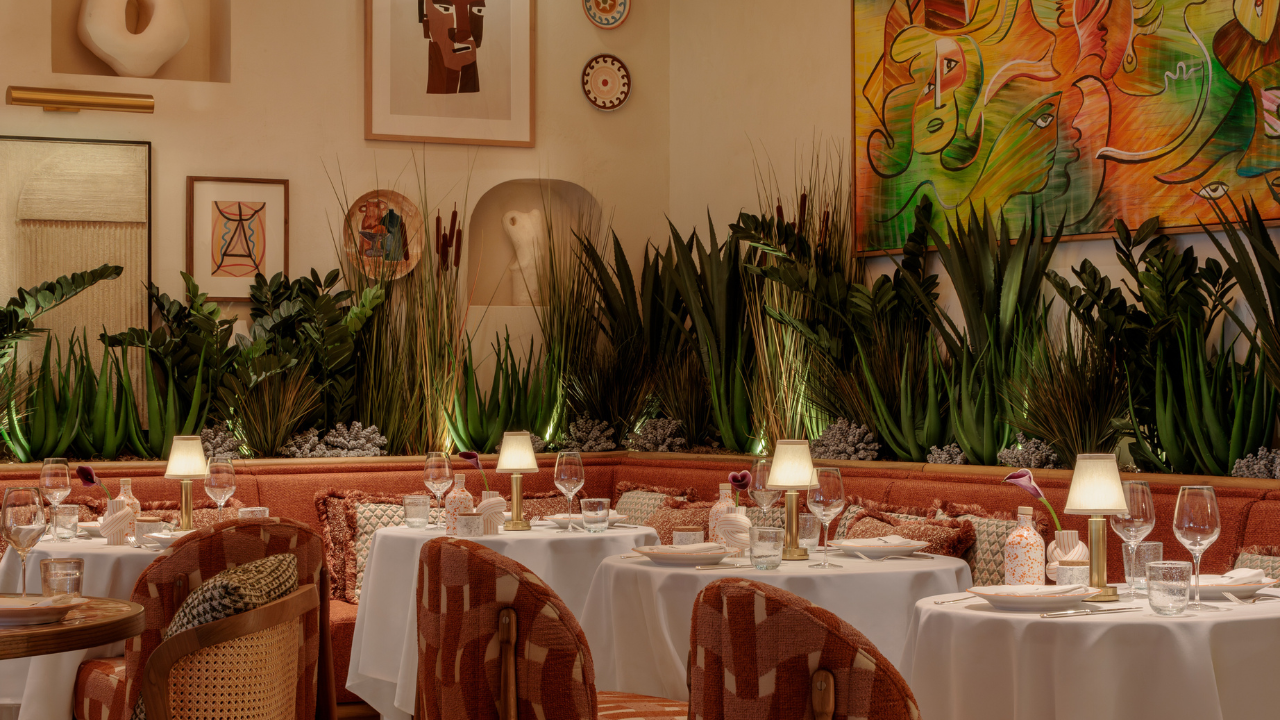 CLAUDIE'S dining interior with a half booth and half tables set up in a Mediterranean Riviera interior design.