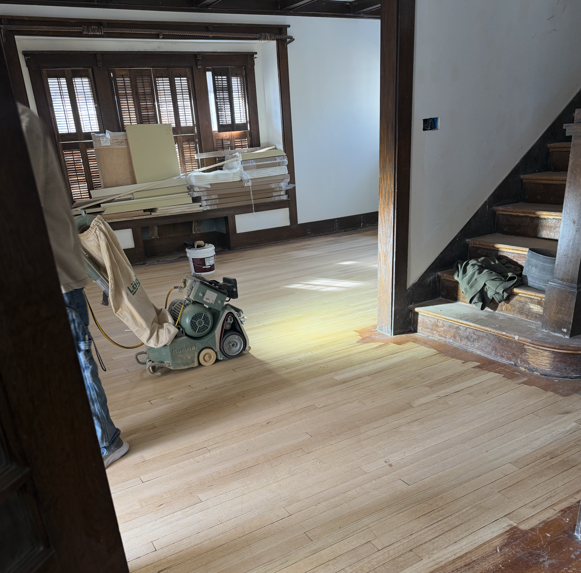The Elizabeth Victorian-style home addition. Mid-project construction showing the interior of a room under renovation with a hardwood floor, construction tools, and building materials. 