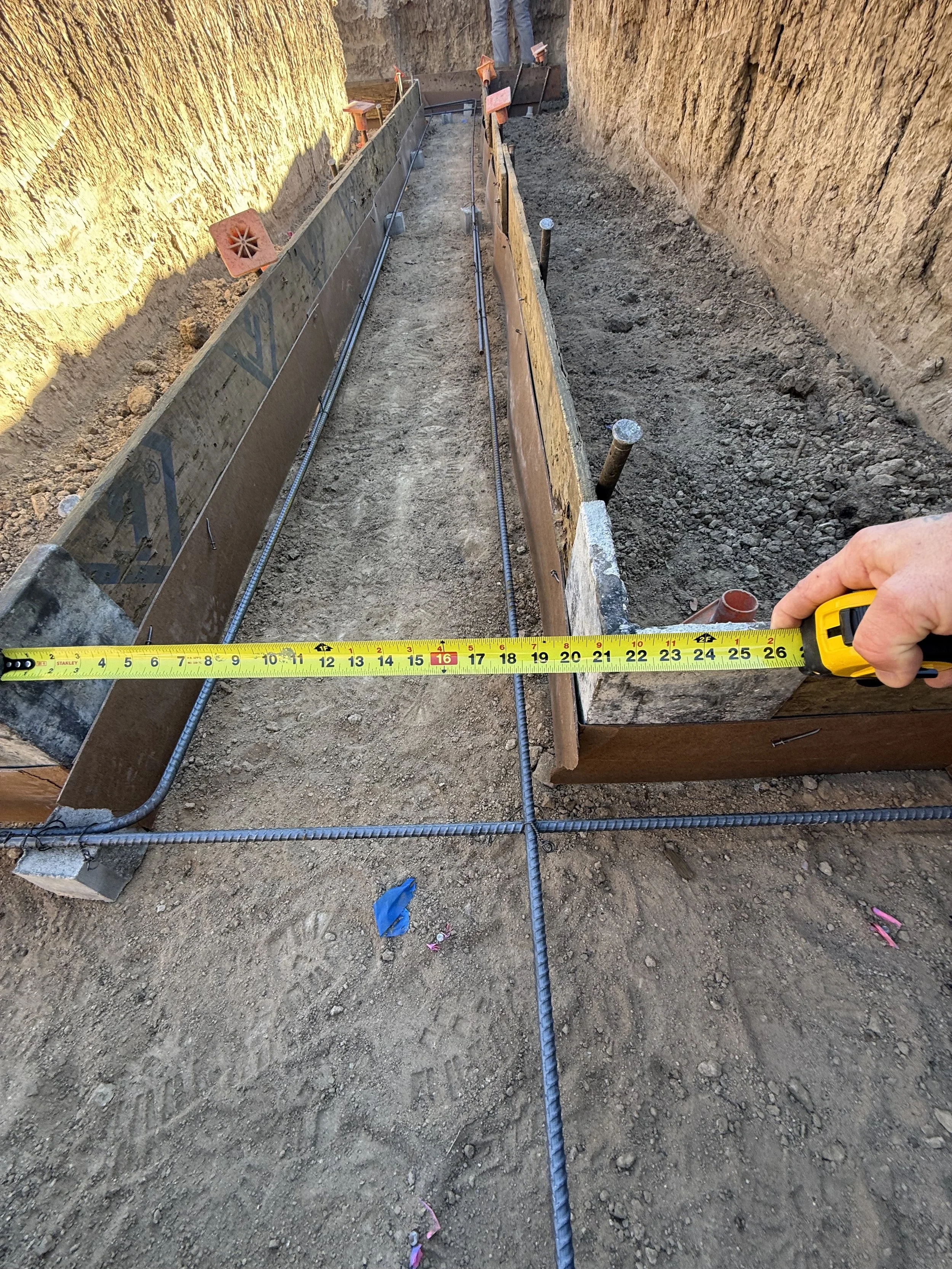 The Elizabeth Victorian-style home addition. Mid-project construction site showing a concrete form with steel rebar and wooden planks