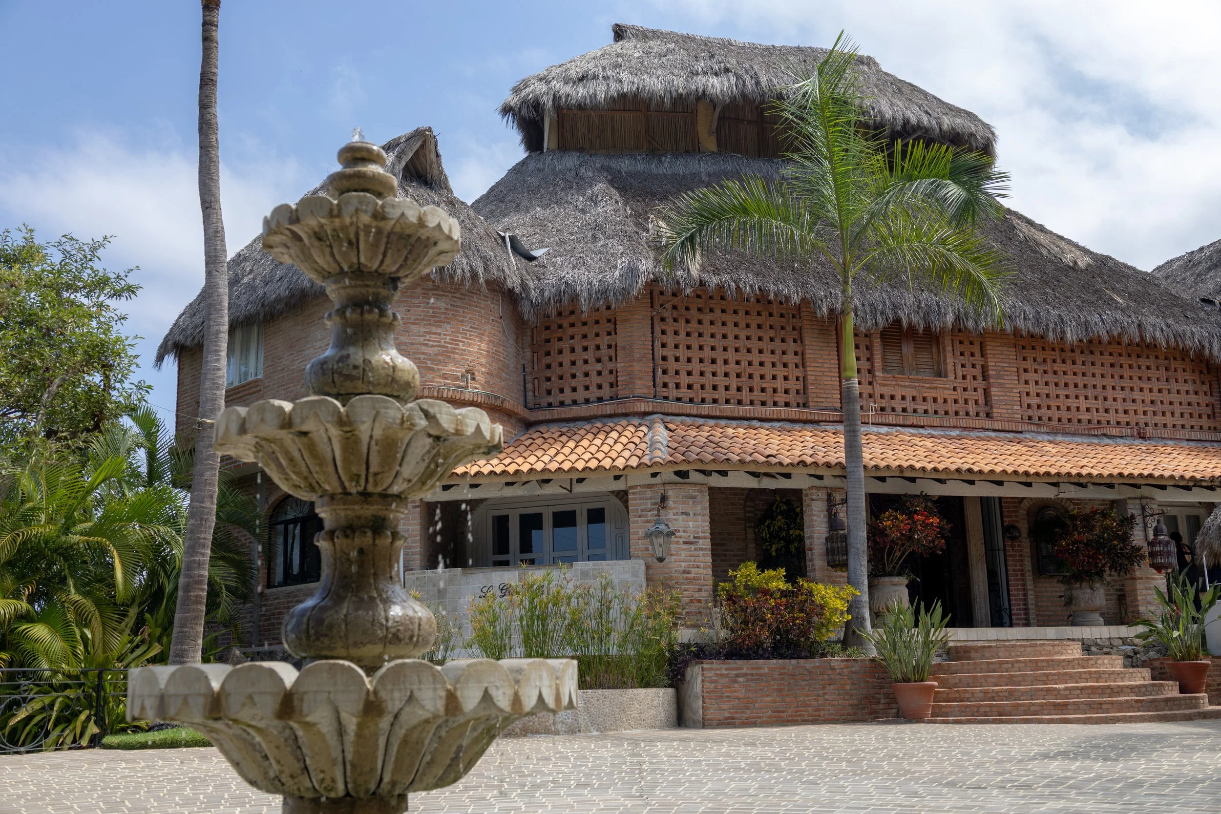 Exterior entrance of Gran Villa vacation rental in Sayulita with stone fountain and tiled roof