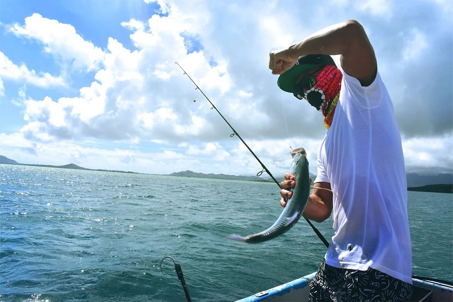 Angler reeling in a catch during a sport fishing boat tour off Sayulita Bay
