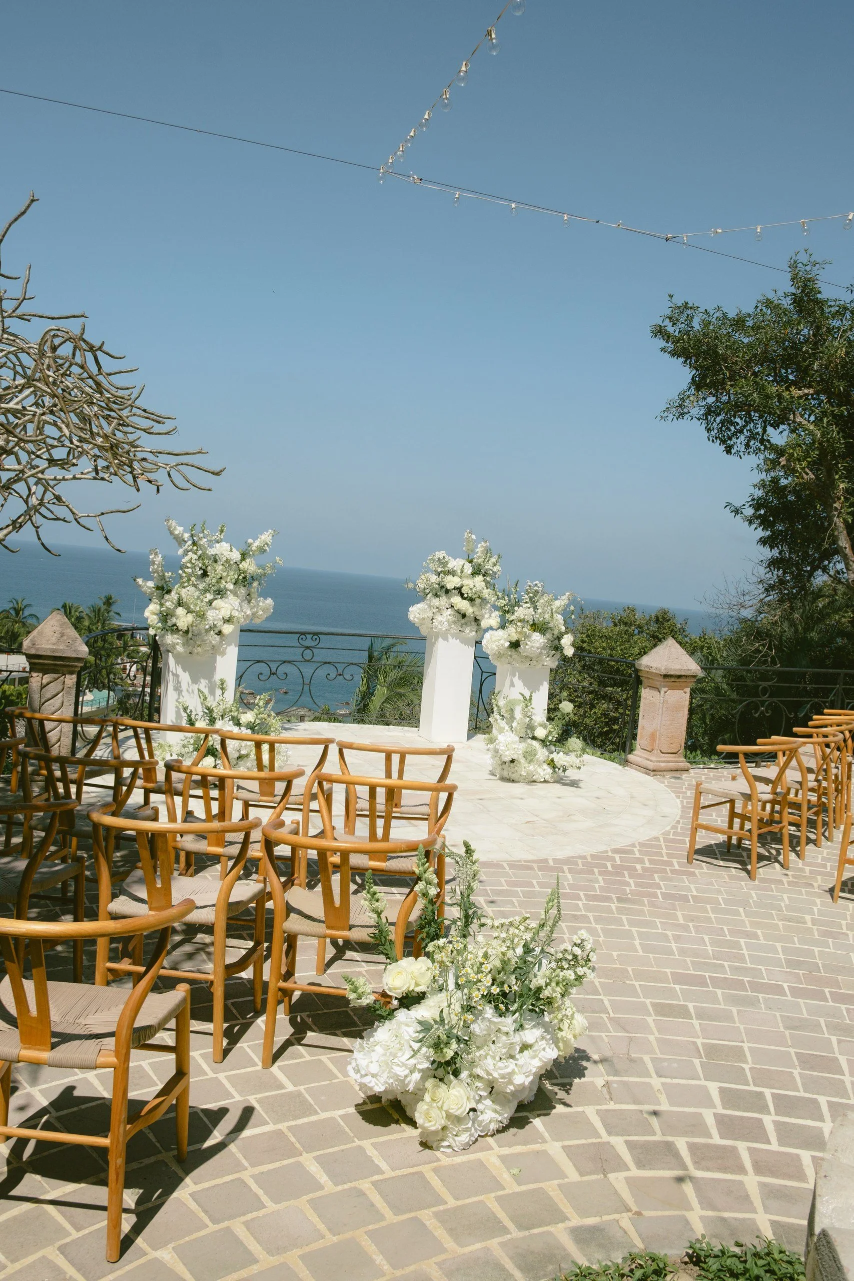 Ocean-view wedding ceremony arch decorated with white florals at Gran Villa, Sayulita
