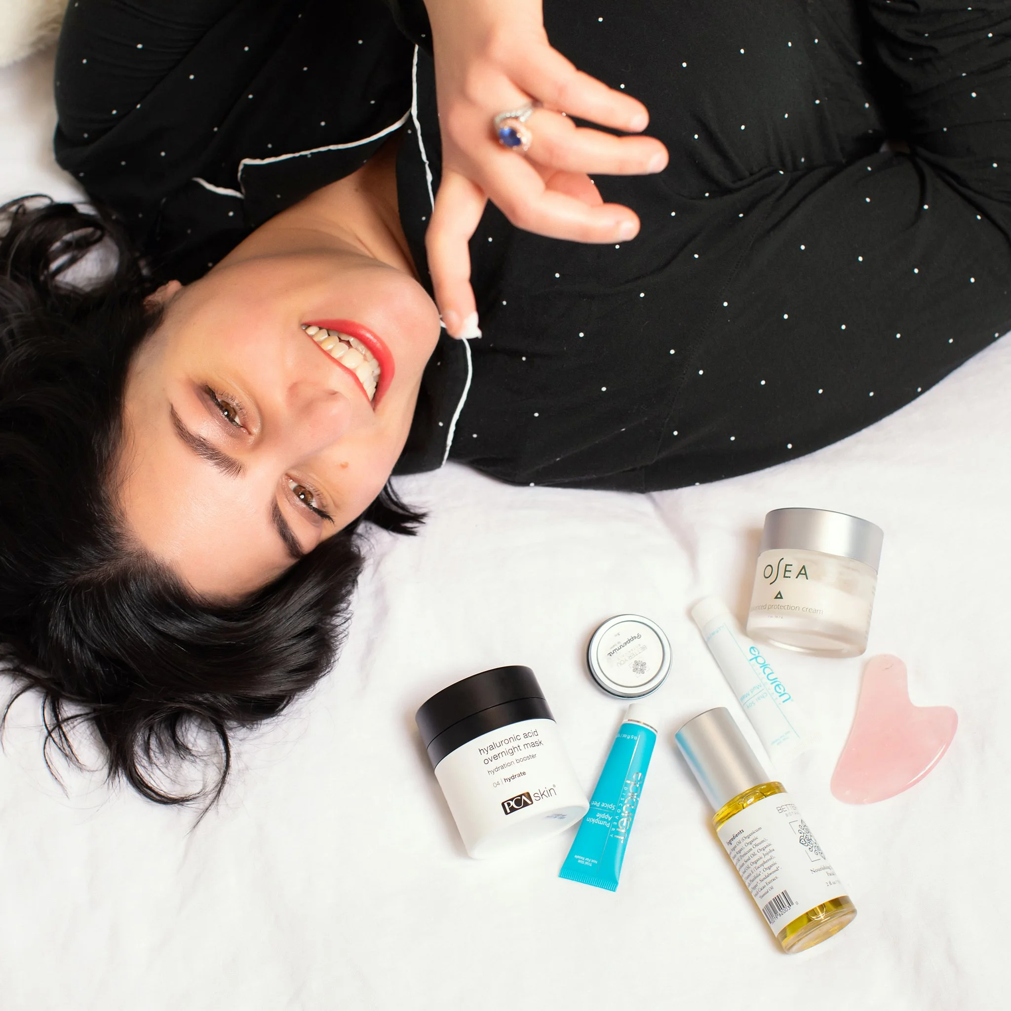 Woman with assortment of skincare products listening to music