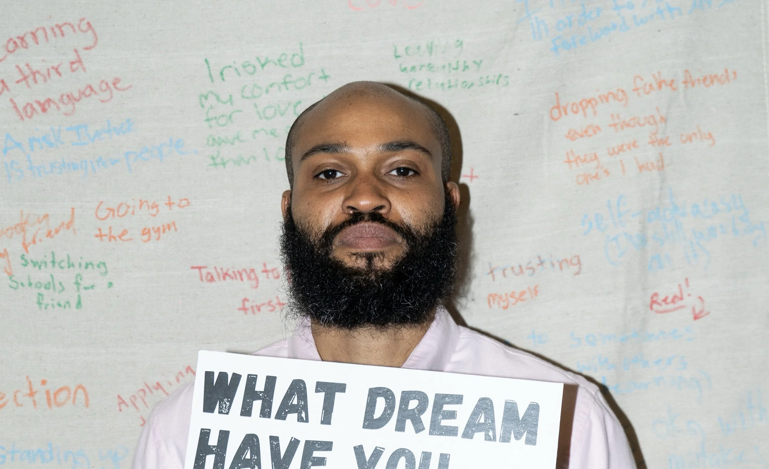 Armstead in front of Textual Tapestry, holding sign
