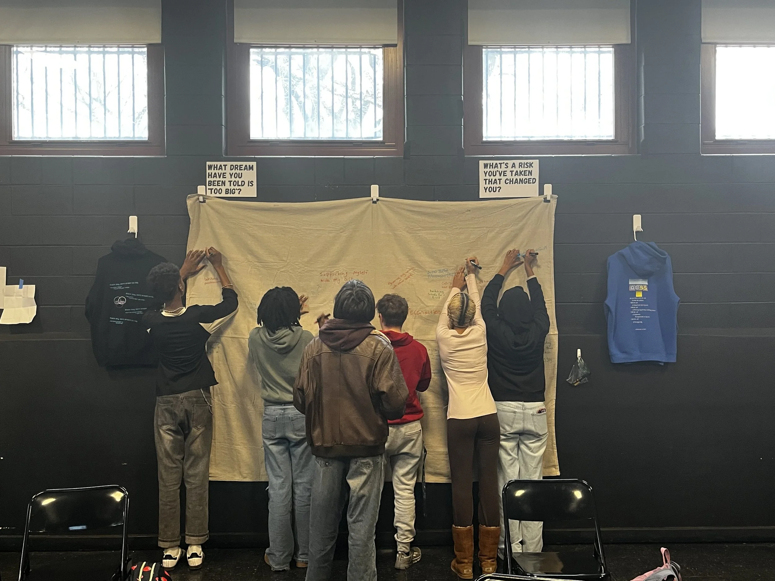 Students writing on tapestry