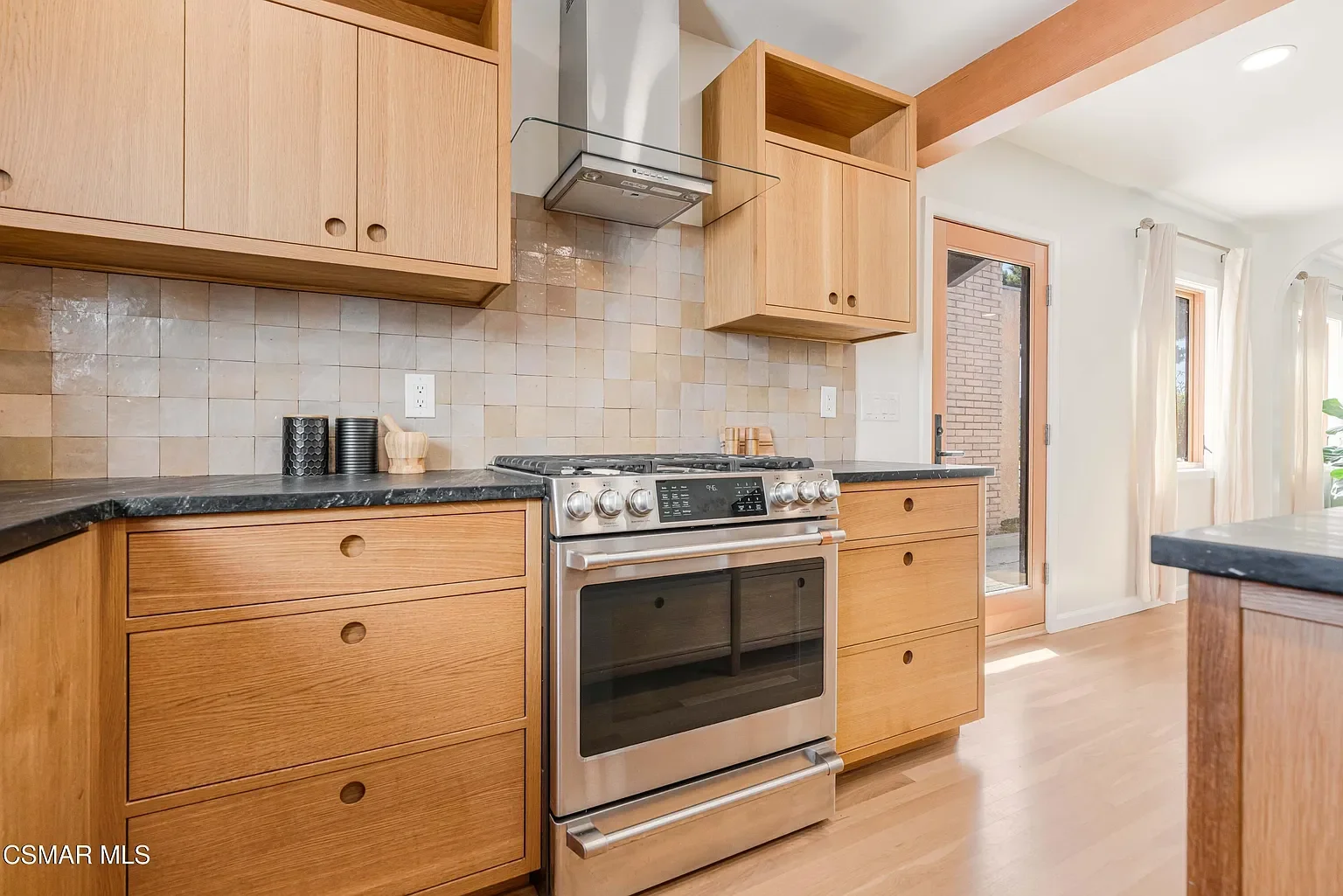 Muted, backsplash in Zia Tile 4x4 Zeilege tile which is an artisan tile with an undulated edge for depth and dimension plus a range in color because of the handmade craftsmanship adds an element of simple elegance . The subtle aesthetic allows the ti