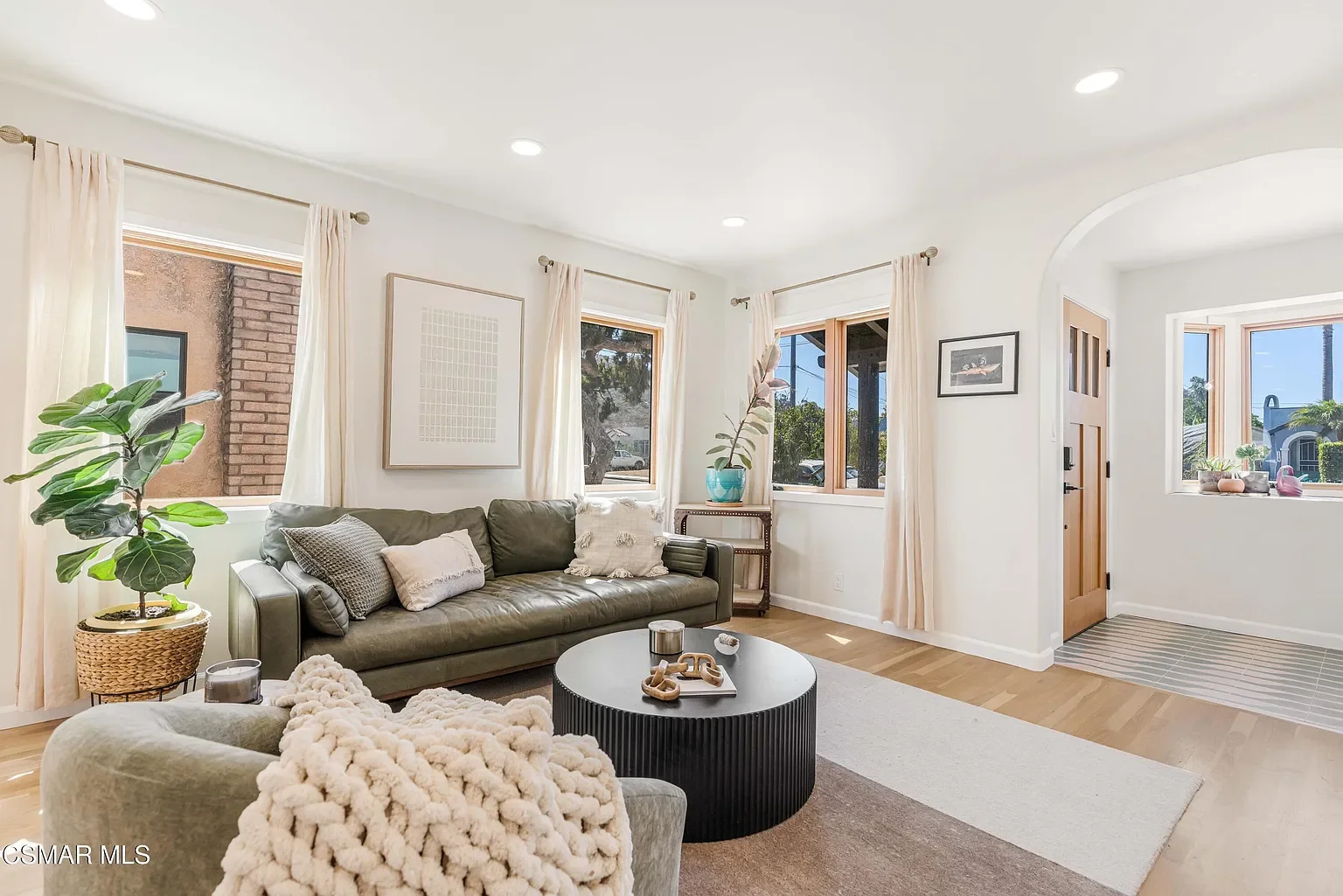 Staging of the living room includes a variety of natural textures, earthy colors, and abstract art for an inviting, warm, yet comfortable place to gather.