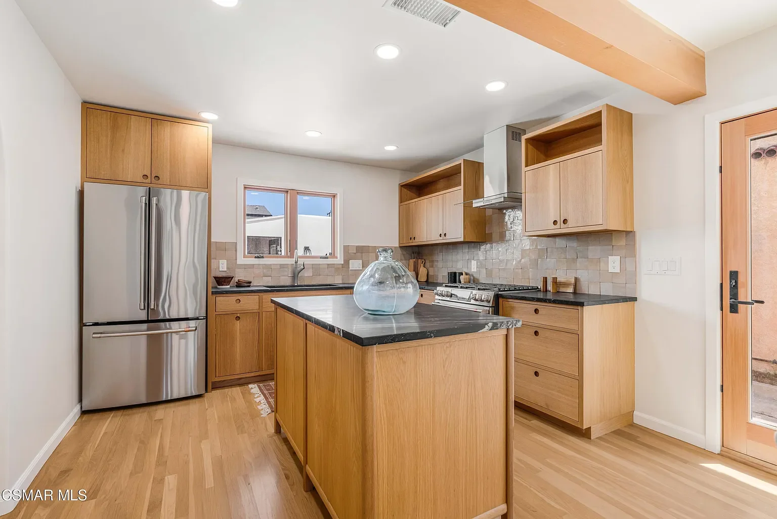 The custom white oak cabinetry was handmade by a local carpenter artisan .