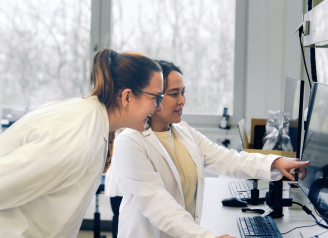 Zwei Laborfachkräfte arbeiten gemeinsam am Computer im Pathologielabor