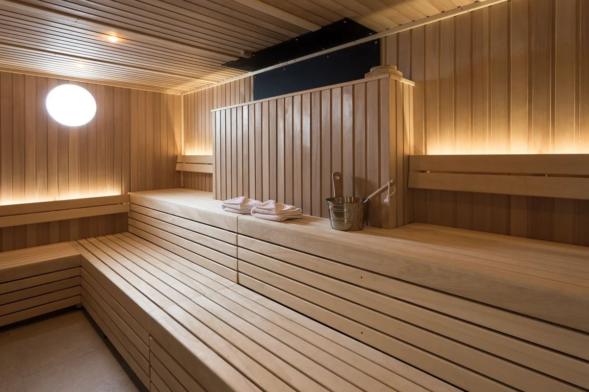 sauna with pale wood panelling and towels