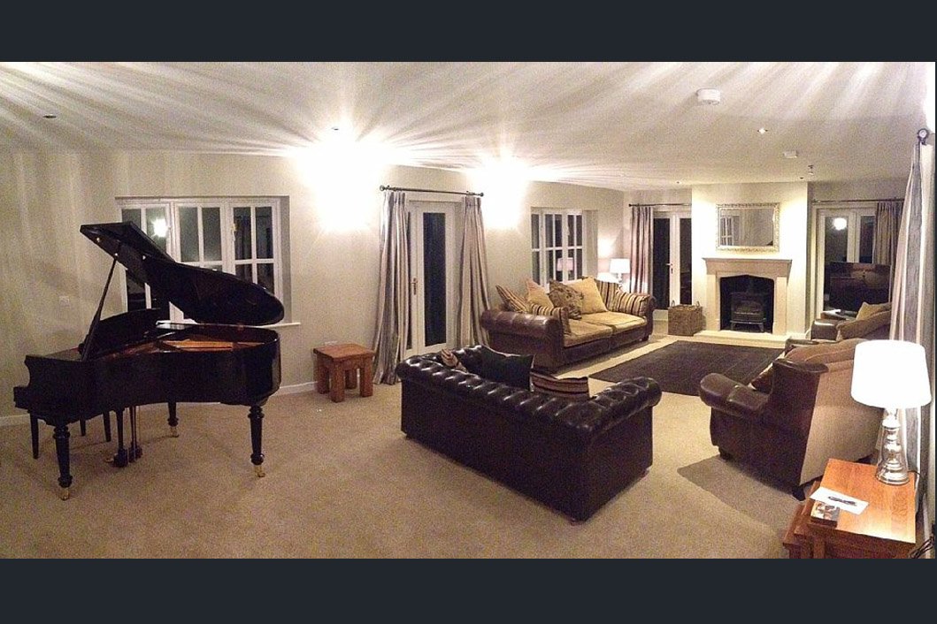  dark image of living room with 3 sofas and grand piano  