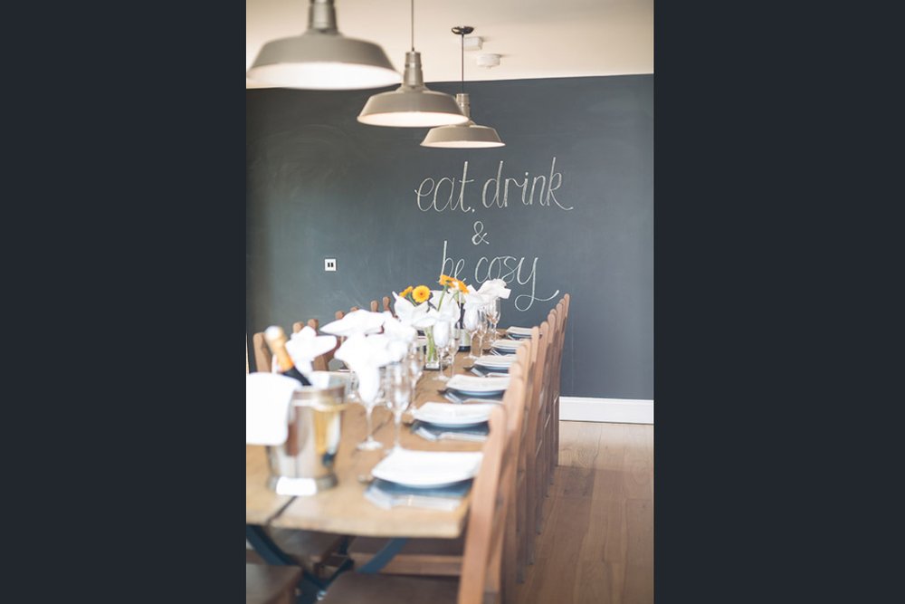  well lit portrait image of dining table with chalkboard wall  