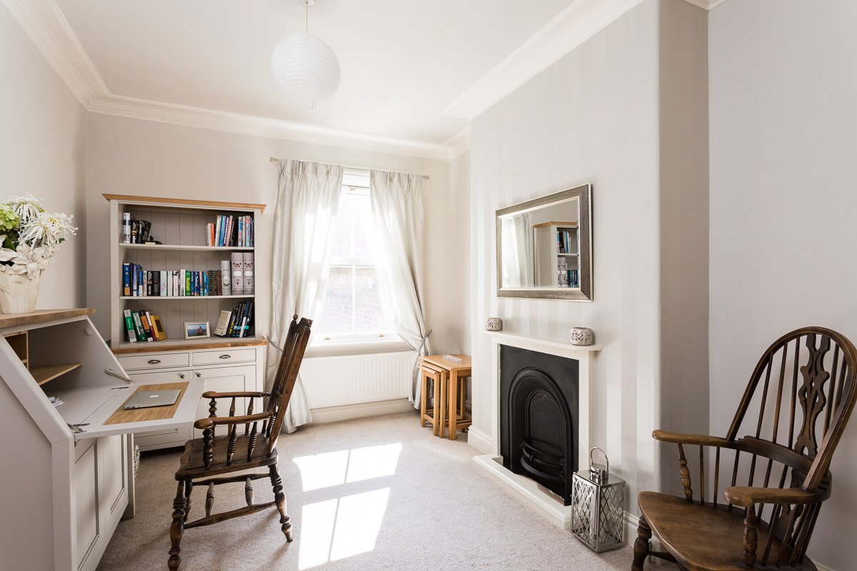  study with pale grey walls, cream carpets, desk, traditional fireplace 