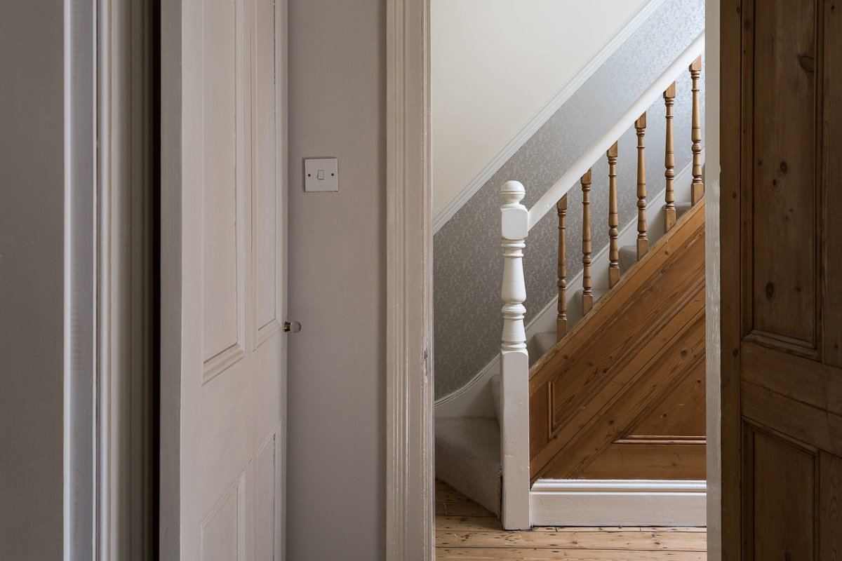  one point perspective looking through doorway at hallway and stairs with wooden flooring  