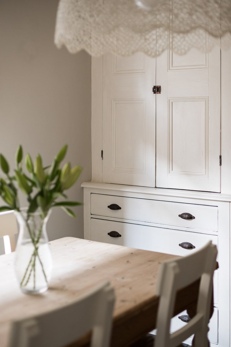  portrait image of detailed wooden unit with flowers on wooden dining table  