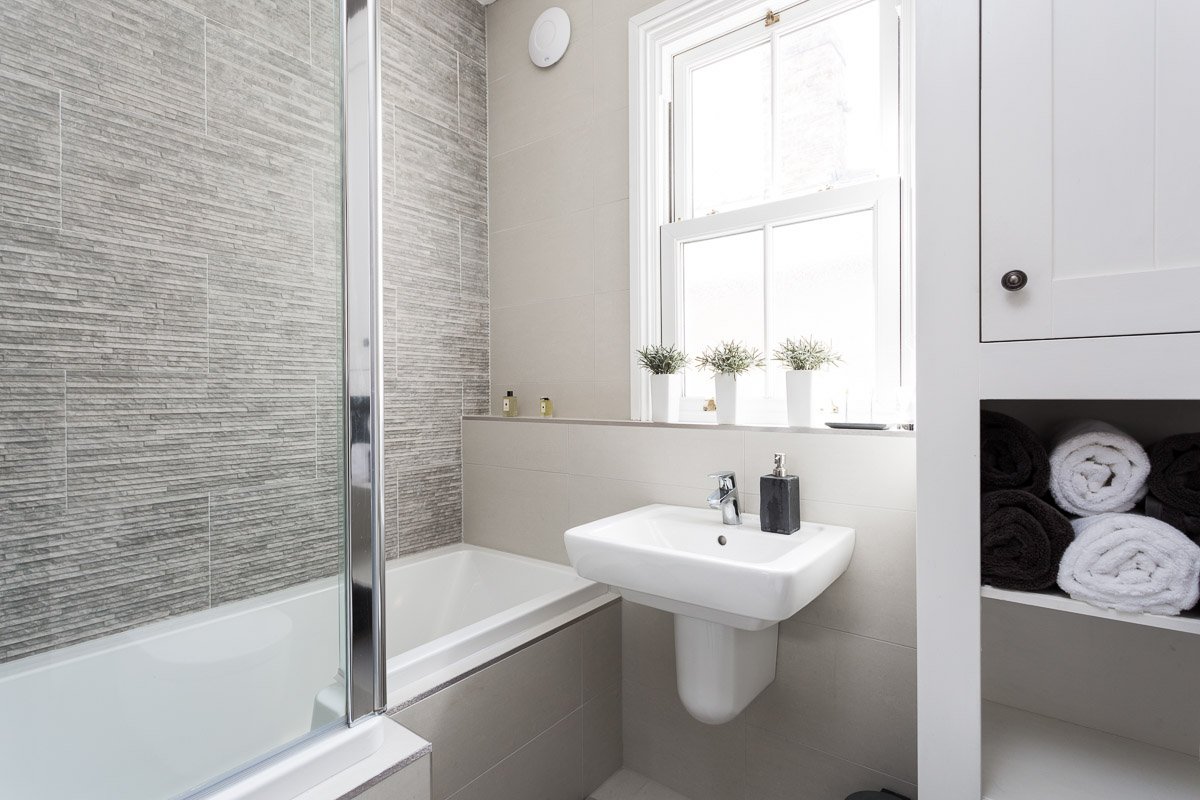  white ang grey bathroom with textured tile wall 