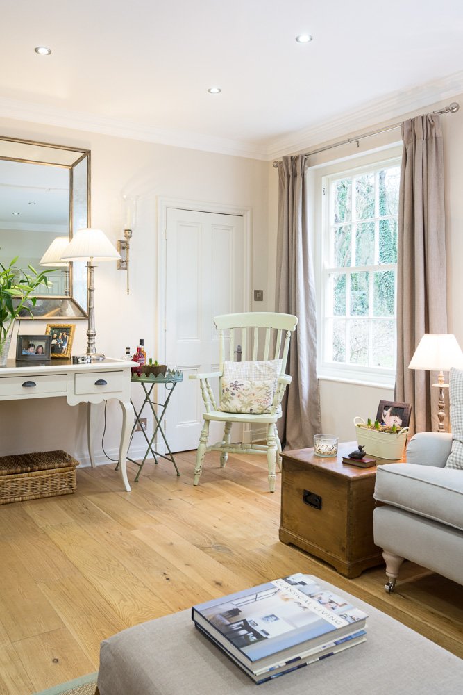  corner of room, bench table with mirror above, sash window on right hand wall and small wooden arm chair 