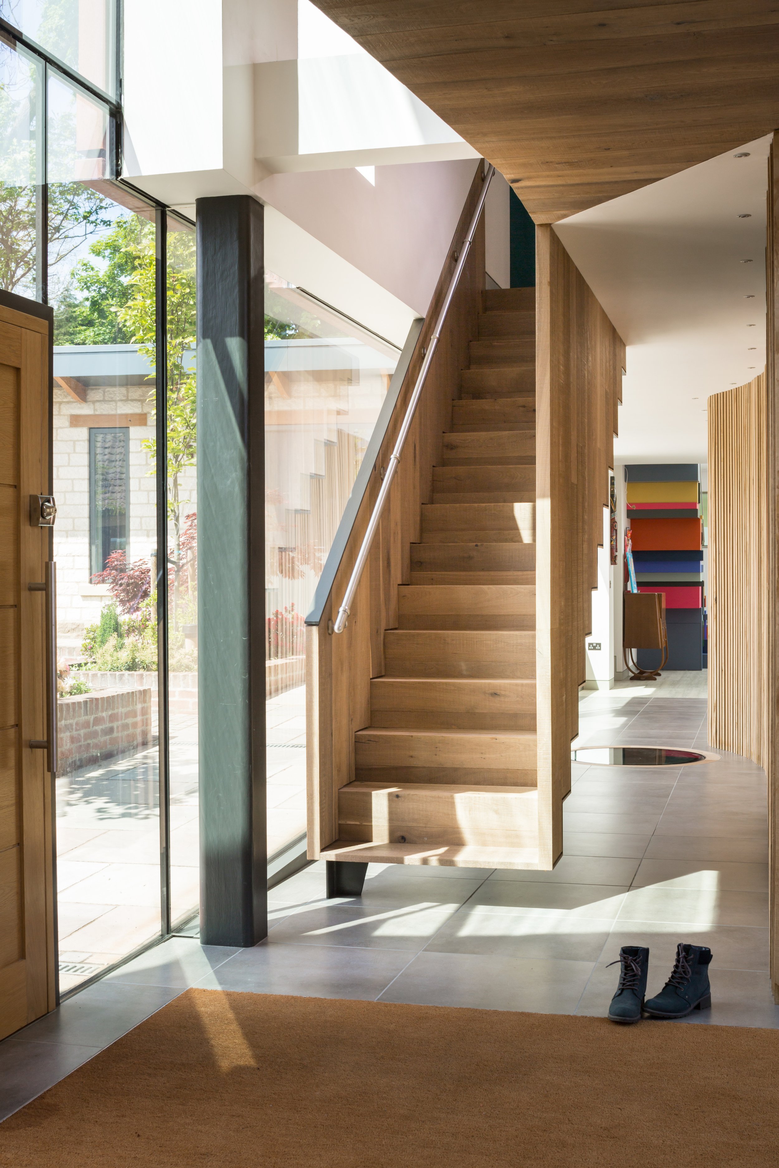 floating oak staircase in contemporary house with fully glazed walls