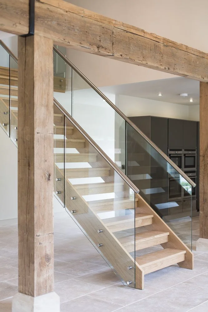 wooden staircase with glass banister