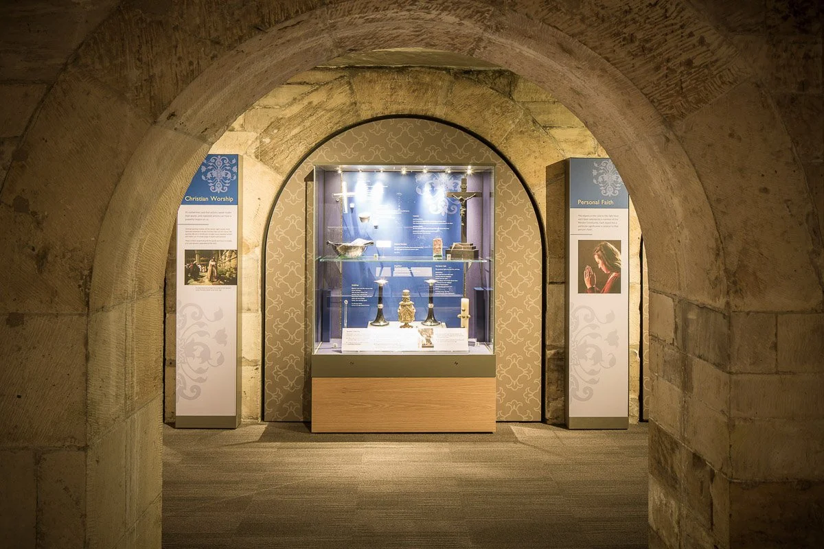 looking through stone archway towards museum exhibition about the building of york minster