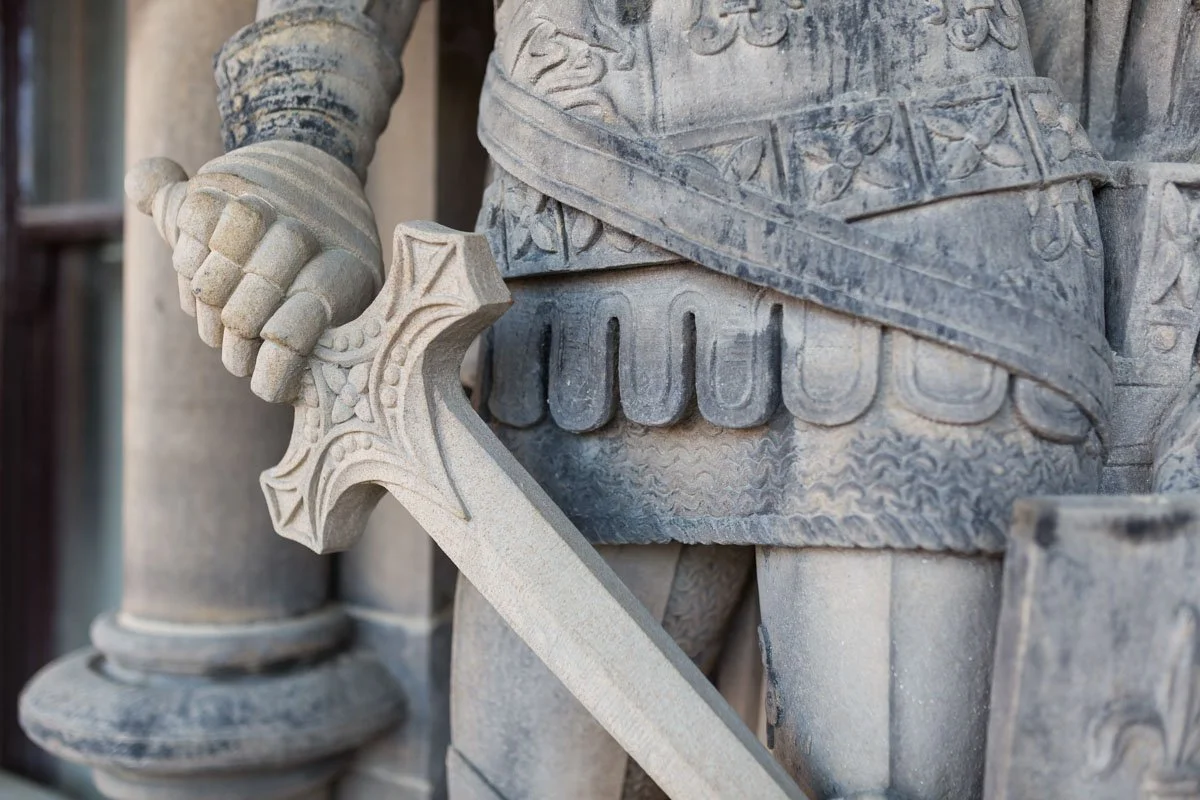 detail of statues holding a sword