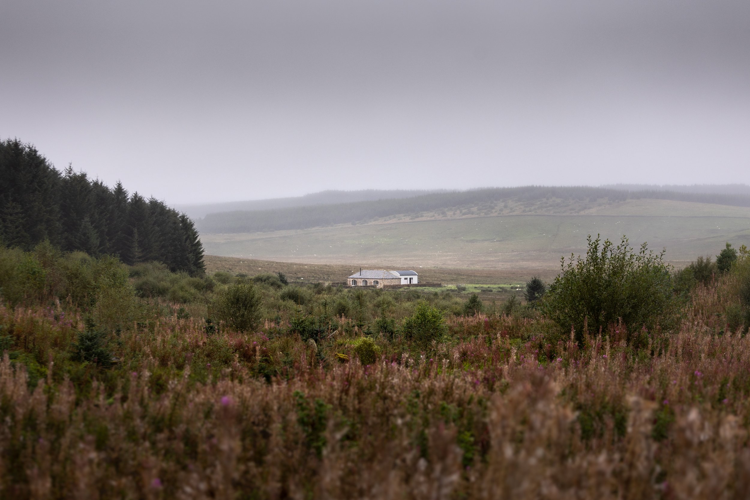 cosy holiday cottage in distance surrounded by foggy moorland