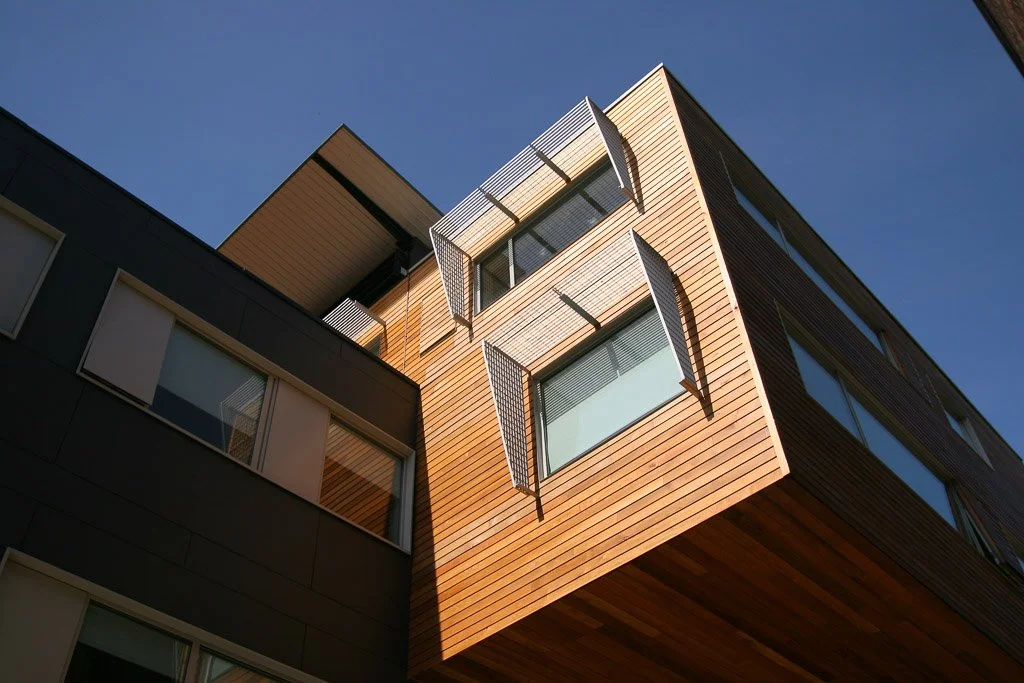 modern cantilever wooden panelled structure on sunny day 