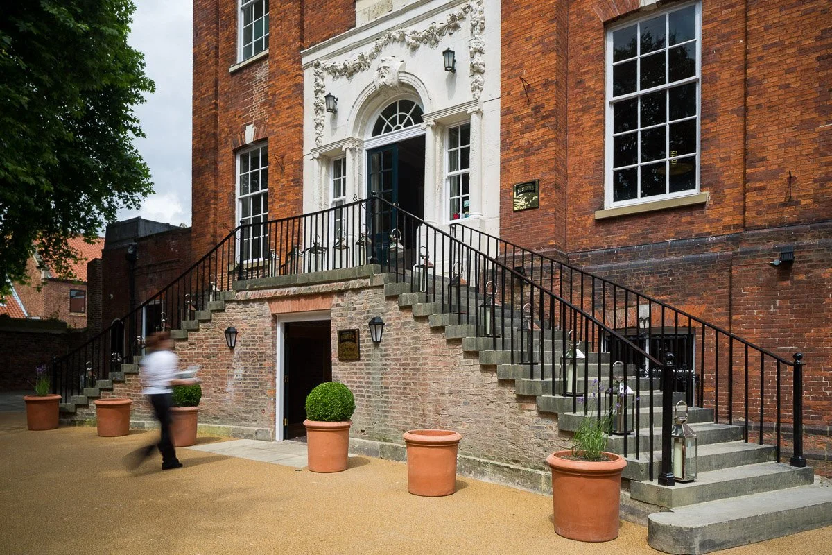 main door and steps of the judges lodgings with blurred waiter going by