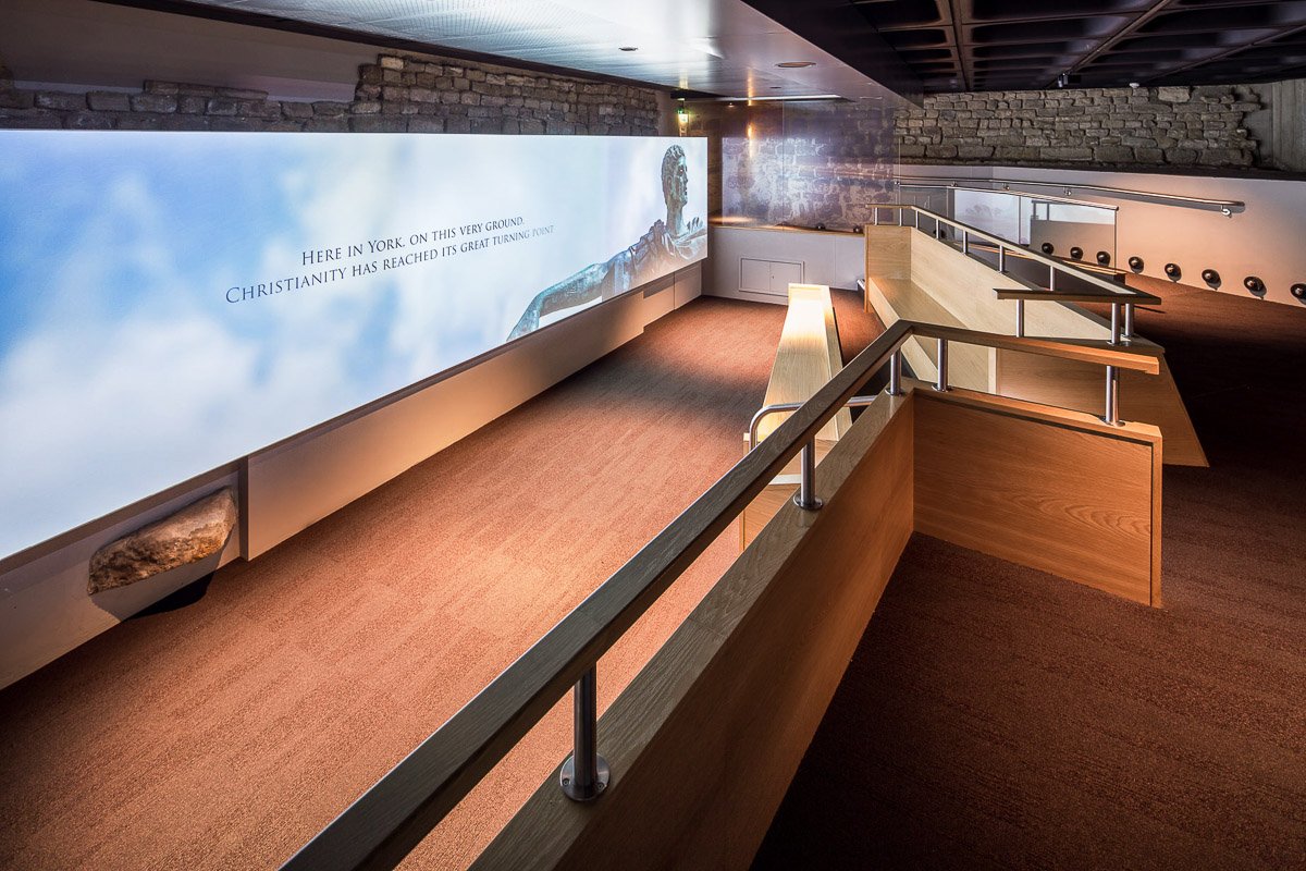 tiered seating in a museum looking towards a projection screen