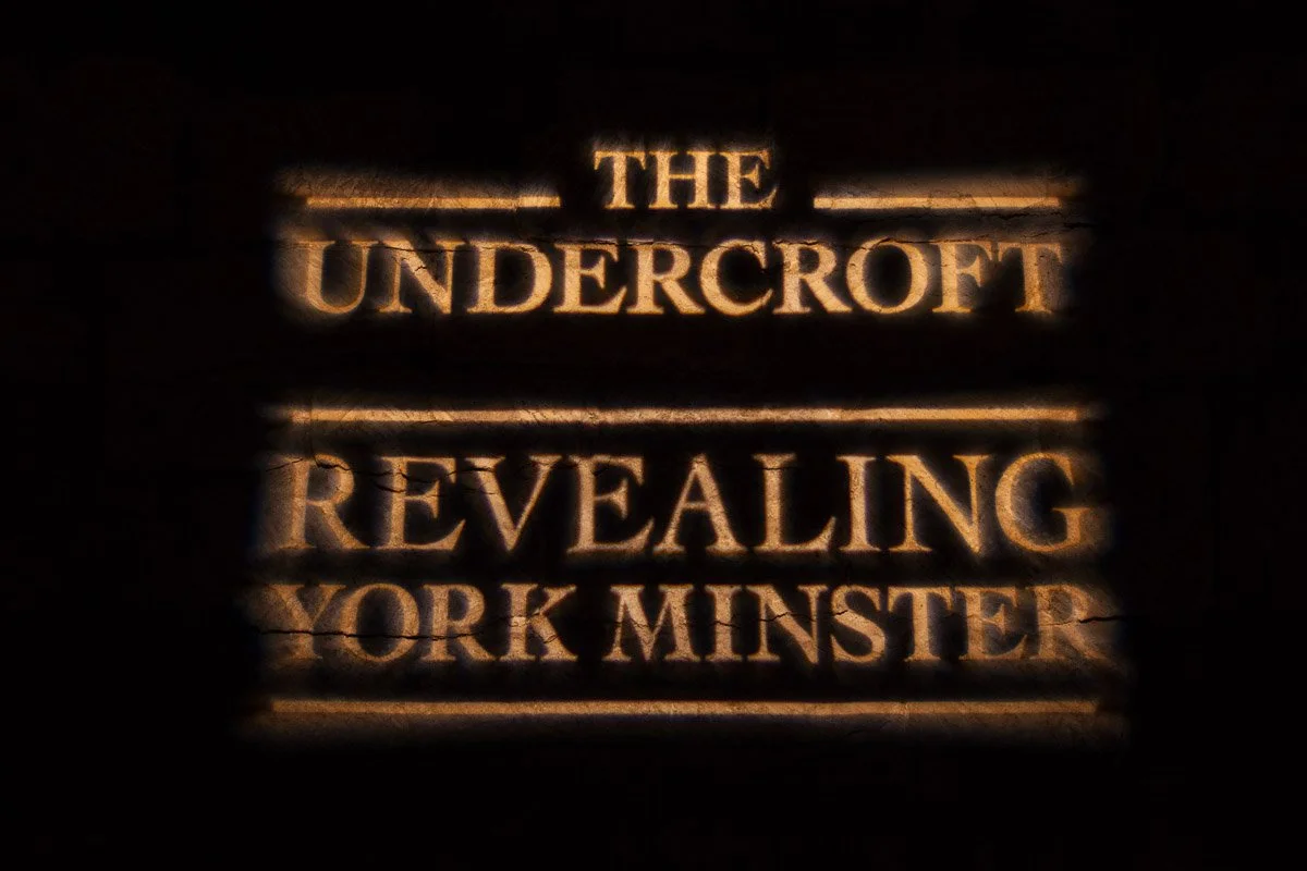 projection of a sign saying 'the undercroft, revealing york minster'