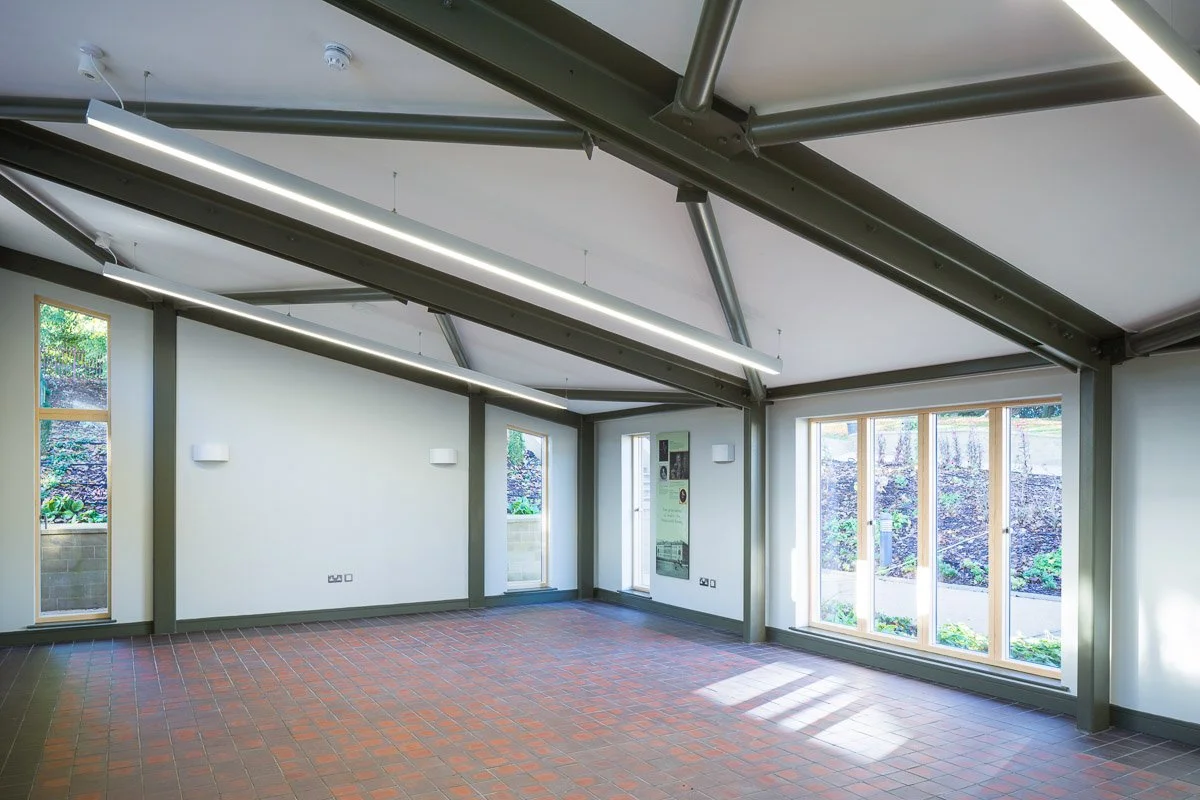 inside an empty newer area of wentworth castle conservatory with red tile floor and sloped ceiling 