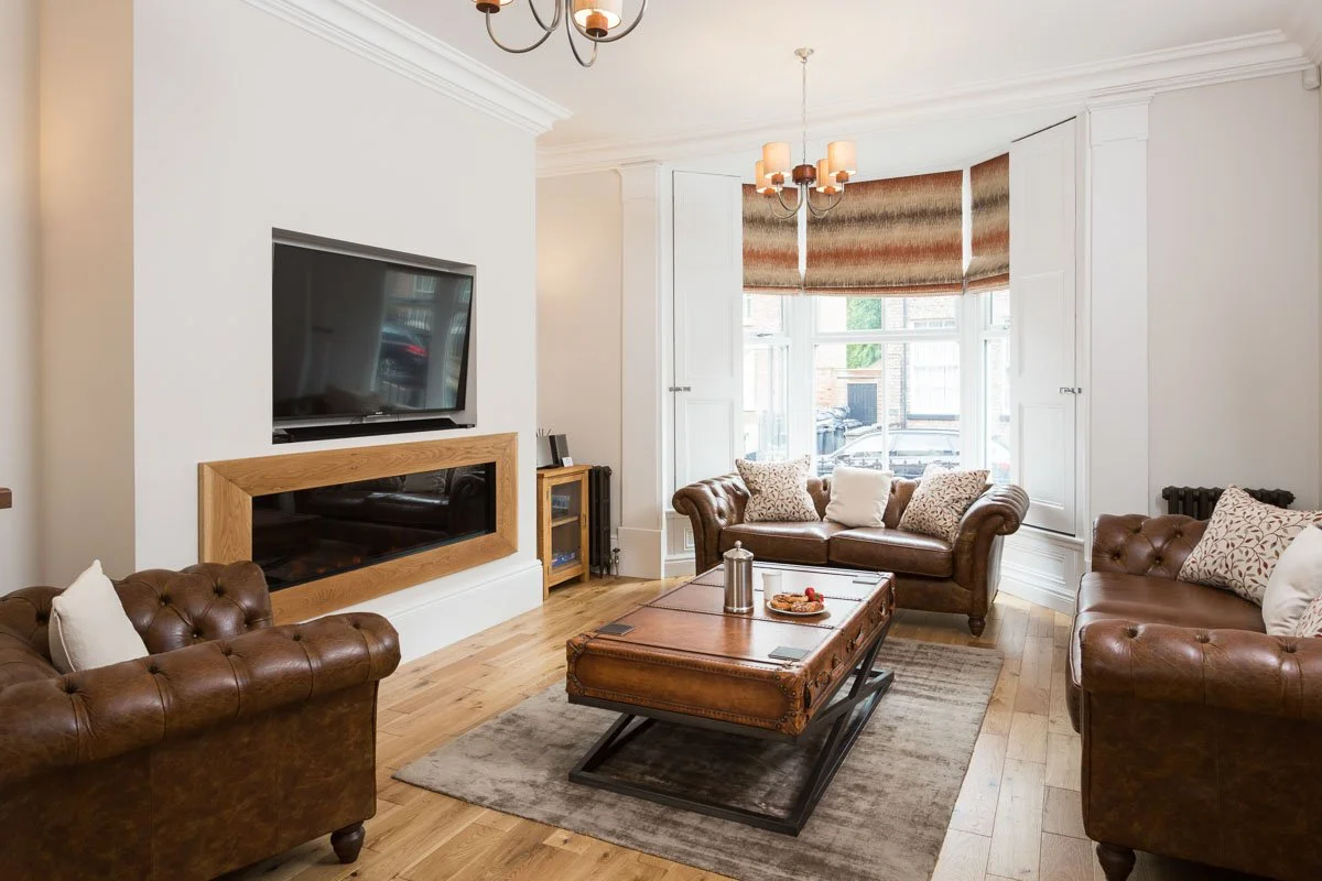 large living room with wooden flooring, large coffee table, leather sofas
