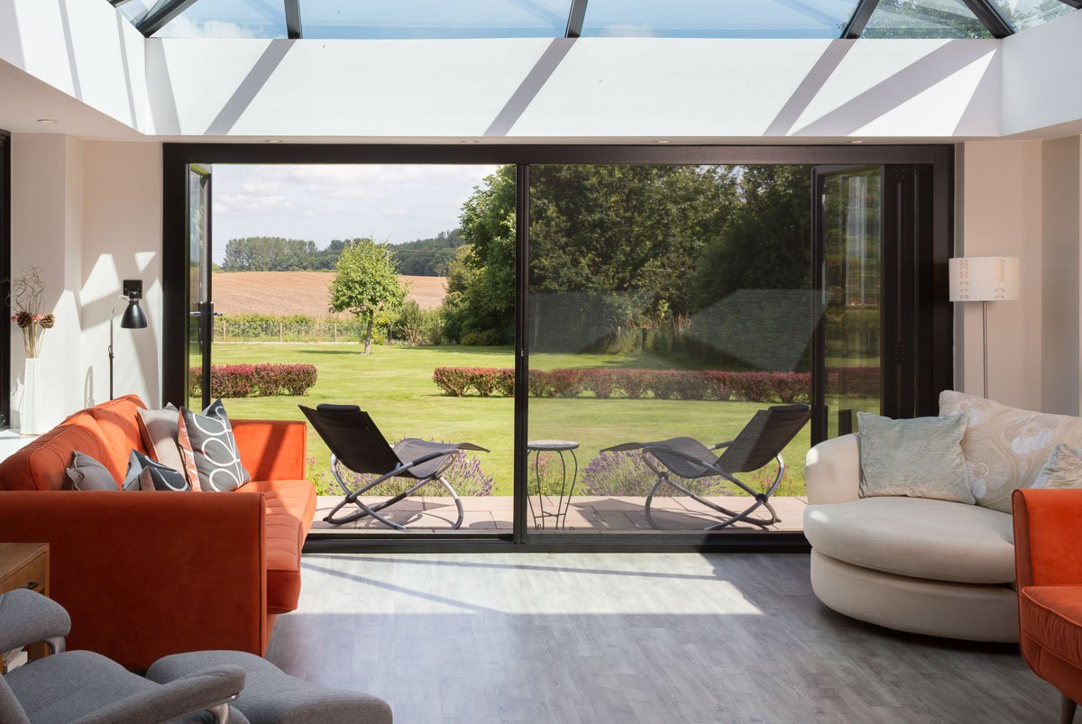 inside garden room with bifold doors, half open bug screen across doors